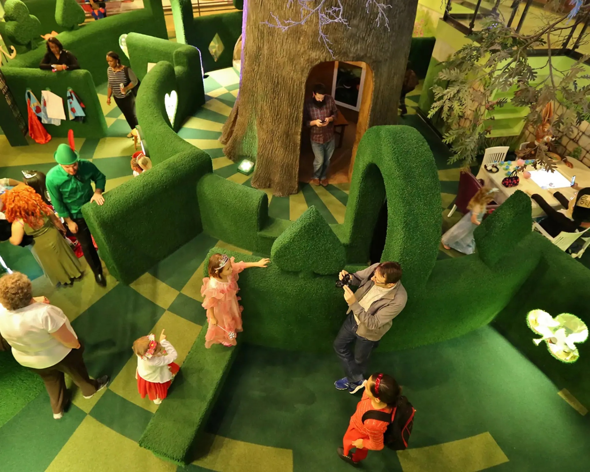 A green topiary-style maze with children and a treehouse