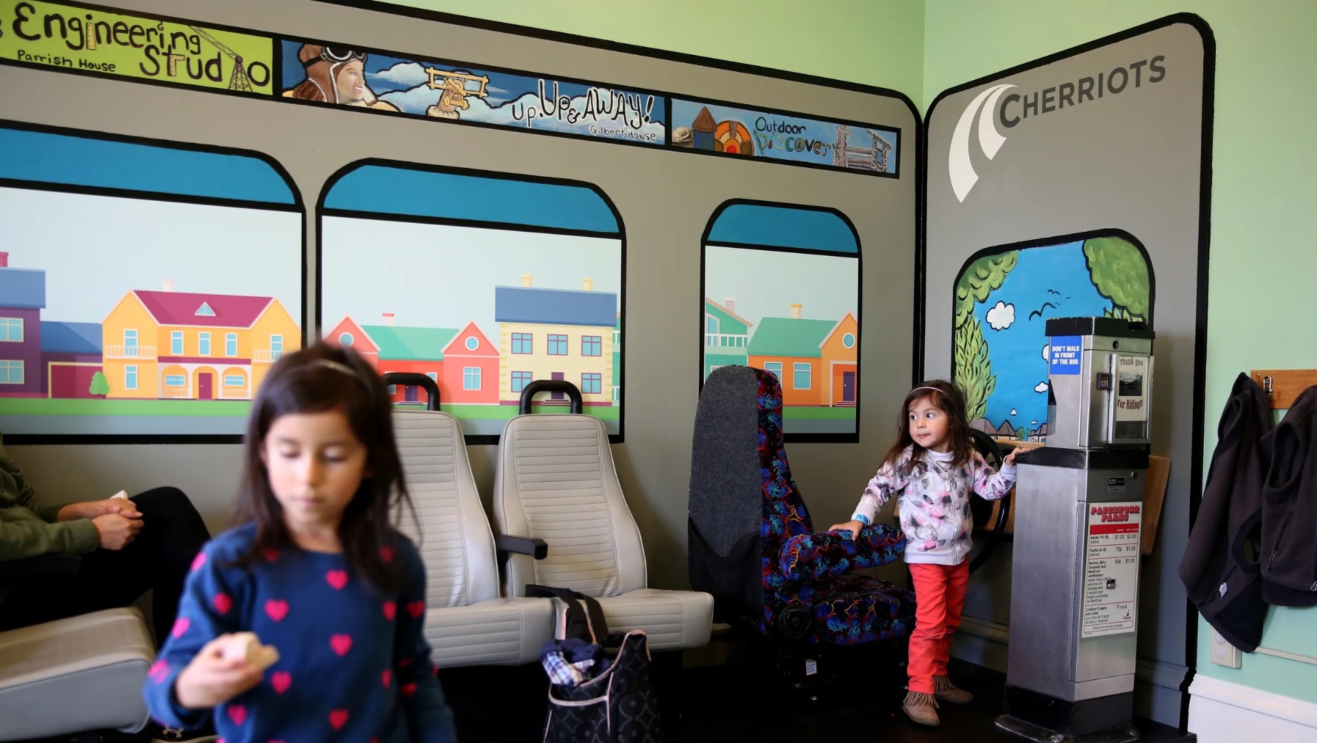 A child exploring a pretend bus dramatic-play exhibit