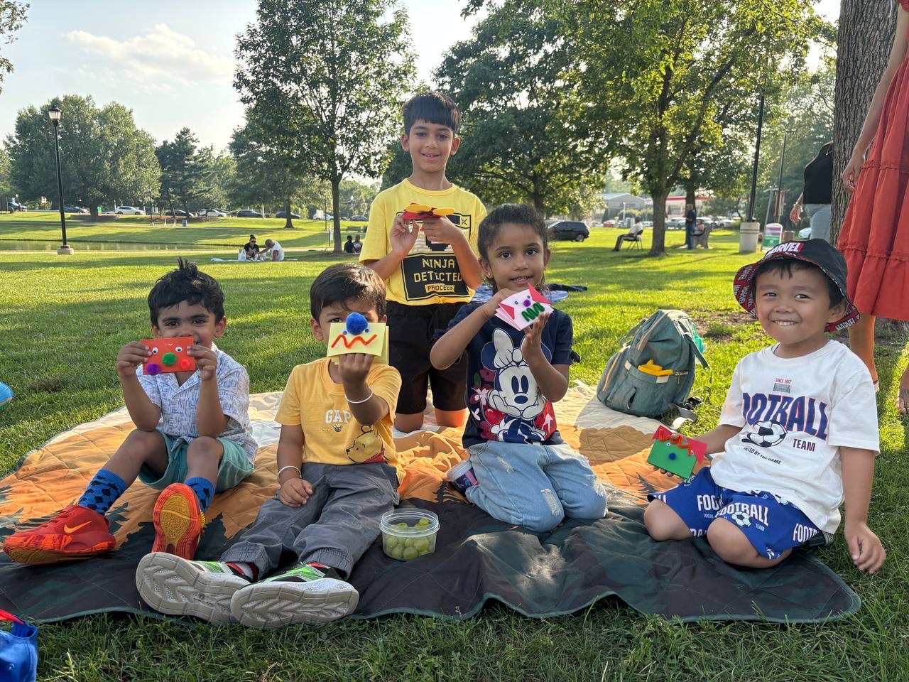Group of kids proudly showing off their crafts in the park