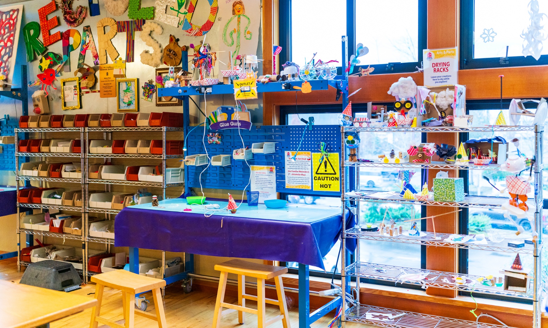 A recycled art lab full of materials, tools, and kid-made creations