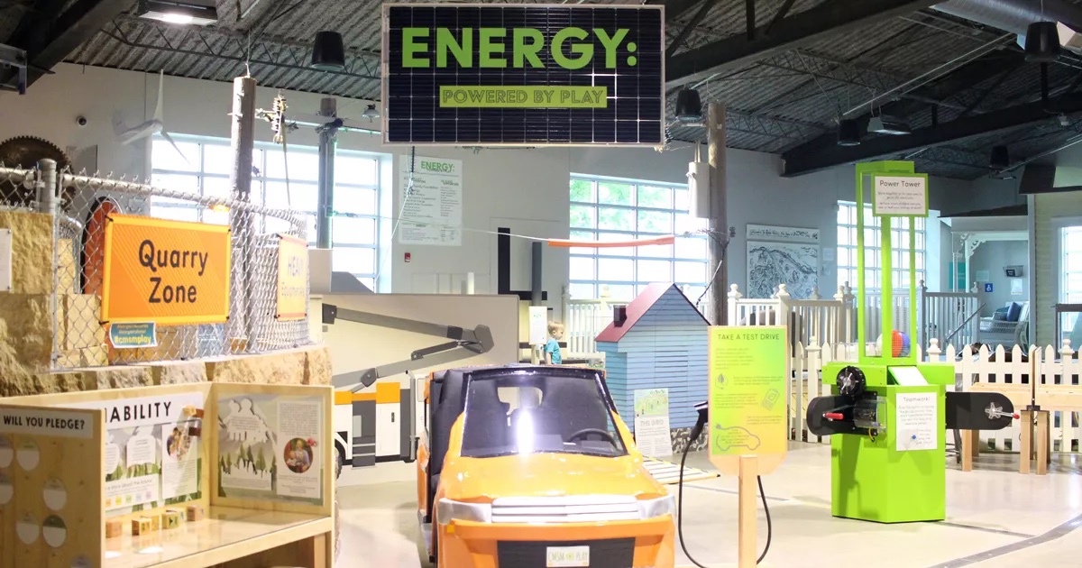An energy-themed exhibit with a solar panel sign and toy vehicles